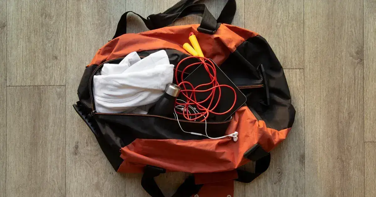 Hiking and survival equipment organised on a wooden surface for building an evacuation bag