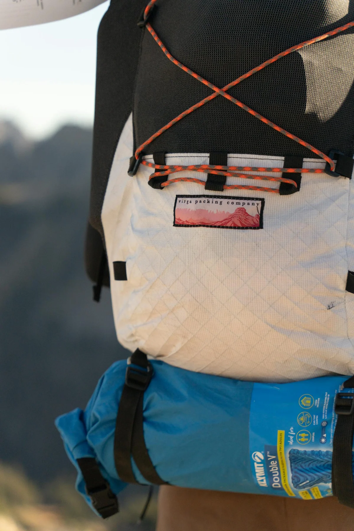 Survival rucksack with kit laid out: torch, multi-tool, water, food, first-aid kit